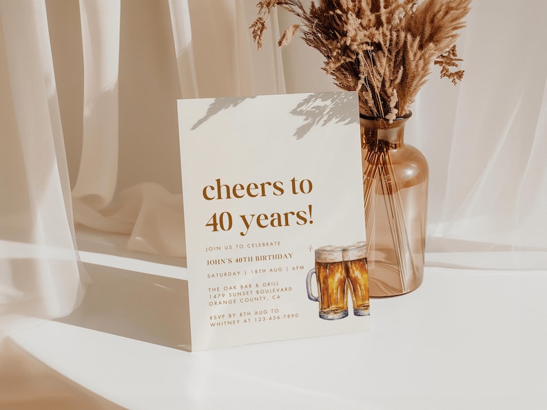May include: A birthday invitation with the text "cheers to 40 years!" in a stylish font. The invitation includes details for John's 40th birthday celebration, featuring a beer mug illustration. A vase with dried flowers is in the background.