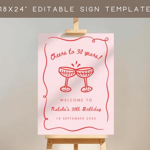 May include: A pink sign with red text and illustrations, displayed on a wooden easel. The sign reads "Cheers to 30 years!" and "Welcome to Natalie's 30th Birthday, 18 September 20XX." The sign is 18x24 inches.