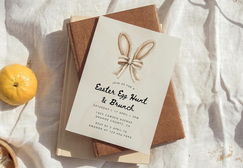 May include: A white invitation card with a watercolor illustration of bunny ears and a bow. The text on the card reads "Join us for a Easter Egg Hunt & Brunch, Saturday 17 April 2PM, 1425 Camden Avenue, Orange County, CA, RSVP by 5 April to Amanda at 123-456-7890".