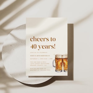 May include: A birthday invitation with the text "cheers to 40 years!" in brown lettering. The invitation includes details for John's 40th birthday, with watercolor illustrations of two beer mugs. The invitation is on a white background.