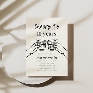 May include: A white invitation card with black text and a simple line drawing of two hands clinking glasses. The text reads "Cheers to 40 years!" and "Join us to celebrate John's 40th Birthday".