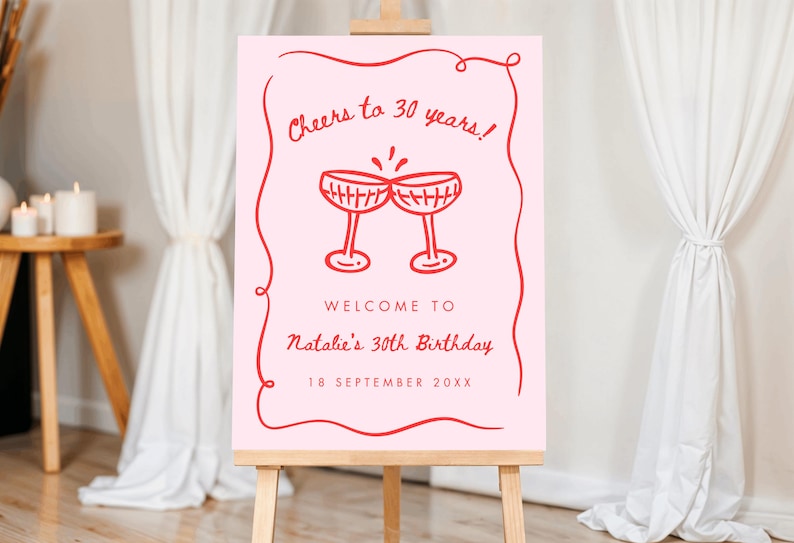 May include: A pink sign on an easel with red text that reads "Cheers to 30 years!" and "Welcome to Natalie's 30th Birthday, 18 September 20XX." Two red champagne glasses are drawn above the text.