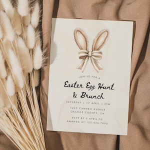 May include: A white card with brown bunny ears and a bow on top. The card is an invitation to an Easter Egg Hunt and Brunch on Saturday, April 17th at 2 PM. The address is 1425 Camden Avenue, Orange County, CA. RSVP by April 5th to Amanda at 123-456-7890.