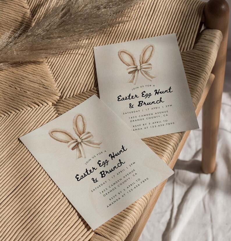 May include: Two light brown invitation cards with a watercolor illustration of bunny ears and a bow. The text on the cards reads "Join us for a Easter Egg Hunt & Brunch" with the date, time, and location details.