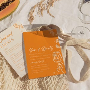 Pode incluir: Um cart&atilde;o de convite laranja e branco com o texto "Sun & Spritz" e um gr&aacute;fico de um copo de sumo de laranja. O convite &eacute; para um fim de semana de despedida de solteira celebrando Amanda Smith em Palm Springs, Calif&oacute;rnia, de 23 a 25 de agosto de 2024.