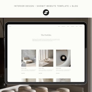 May include: A digital tablet displays a website template with the text "INTERIOR DESIGN - SHOWIT WEBSITE TEMPLATE + BLOG". The website showcases a portfolio with images of interior design projects. A black vase and decorative items are in the foreground.