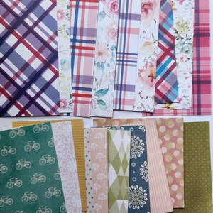Pode incluir: Uma cole&ccedil;&atilde;o de folhas de papel retangulares com padr&otilde;es diversos, incluindo xadrez roxo e vermelho, estampas florais em aquarela, motivos de bicicletas verdes, listras amarelas, formas geom&eacute;tricas, mandalas azuis e bolinhas coloridas.