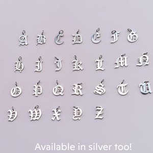 a collection of silver alphabet charms arranged in rows, each containing a single letter.