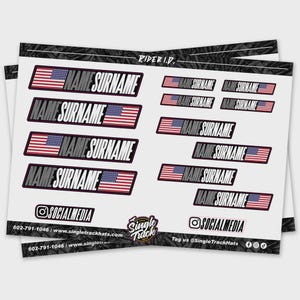 May include: A sheet of stickers featuring the American flag and the text "NAME SURNAME." The stickers are rectangular with a red, white, and blue color scheme. The sheet also includes social media handles and the Single Track logo.