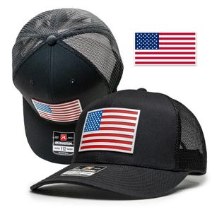 May include: Black trucker hat with a mesh back and a red, white, and blue American flag patch on the front. The hat has an adjustable strap and the Richardson logo is visible on the side.