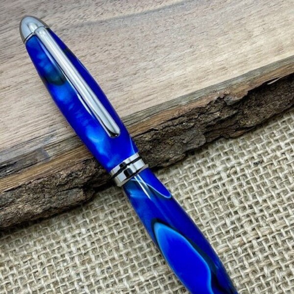 Executive style, blue acrylic ballpoint pen with chrome accents.