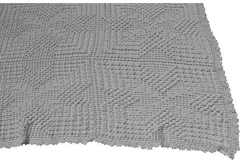 May include: A gray crocheted throw blanket with a textured pattern. The blanket has a fringed edge.