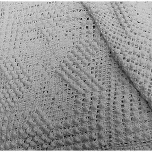 May include: White crocheted baby blanket with a diamond pattern. The blanket is made of soft, lightweight yarn and is perfect for keeping a baby warm and cozy.