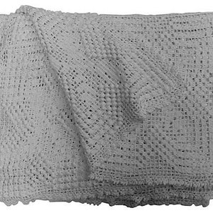 May include: A white crocheted baby blanket with a delicate pattern. The blanket is folded in half and has a soft, textured surface.