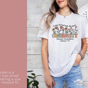May include: A grey t-shirt with a floral design and the text "To know God and make Him known COMMUNITY Classical Conversations Jackson, TN".
