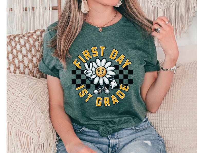 May include: A green t-shirt with a white daisy graphic and the text "First Day 1st Grade" in a black and white checkered pattern.