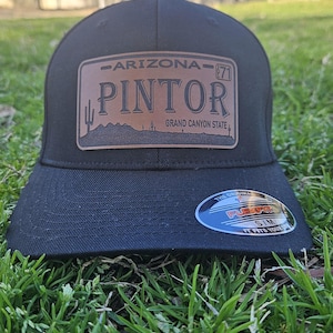 May include: Black baseball cap with a brown leather patch that says "Arizona - Pintor - Grand Canyon State".