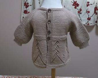 Gilet bébé tricoté main en laine mérinos beige : motif chevron ajouré