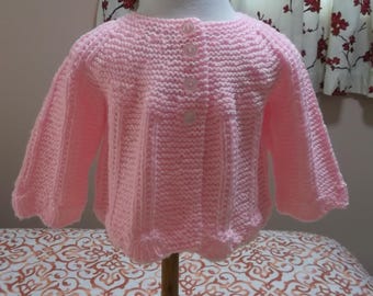 Pull rose pour bébé en tricot à la main avec ourlet festonné