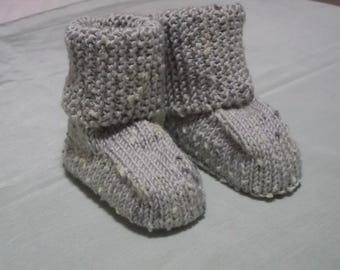 Chaussons bébé tricotés à la main en fil gris avec des taches au point mousse aux poignets