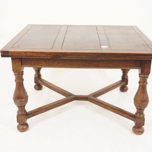 May include: A dark brown wooden table with a square top and four turned legs. The table has a simple, traditional design.