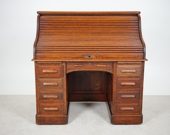 May include: A vintage wooden roll-top desk with a warm, reddish-brown finish. The desk features a slatted roll-top, multiple drawers, and a central kneehole. The desk's dimensions are approximately 127 cm wide, 76 cm deep, and 114 cm high.