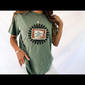 May include: A green t-shirt with a black and white graphic of a vintage television set. The television screen says "The revolution will be televised".
