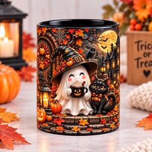 Può includere: Una tazza in ceramica nera con una colorata illustrazione di Halloween raffigurante un fantasma con un cappello da strega che tiene in mano una tazza a forma di zucca, accompagnato da un gatto nero, zucche, foglie autunnali e luna piena.