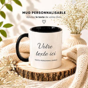 Peut inclure: Un mug blanc avec l'intérieur et la anse noirs. Le mug porte l'inscription "Votre texte ici" en écriture cursive, avec du texte supplémentaire au-dessus et en dessous. Le mug est présenté sur une tranche de bois, avec une couverture crème et des fleurs en arrière-plan.