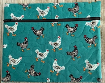 May include: Teal quilted fabric pouch with a black zipper. The pouch is patterned with white and black chickens with red combs. The chickens are walking on a teal background. The pouch is rectangular.