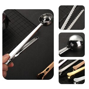 May include: A silver measuring spoon with a clip attached to the handle. The spoon has a serrated edge and is used for measuring coffee grounds. The clip can be used to attach the spoon to a coffee bag.