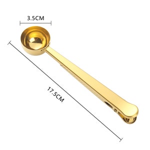 May include: Gold-toned metal coffee scoop with a clip on the handle. The scoop measures 3.5 cm in diameter and the handle is 17.5 cm long.