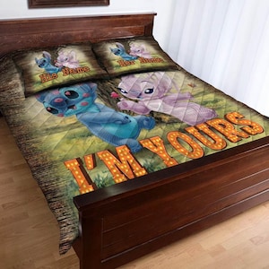 May include: A brown and green quilt set featuring cartoon characters. The quilt has a diamond pattern and the words "I'M YOURS" in orange letters. The pillowcases have the words "His Name" and "Her Name".