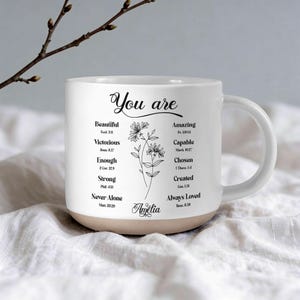 Op de afbeelding: Een set van drie keramische mokken met een gespikkelde, matte afwerking. De mokken zijn in tinten crème, lichtgrijs en donkergrijs. Elke mok heeft een eenvoudig, minimalistisch ontwerp, perfect voor koffie of thee.