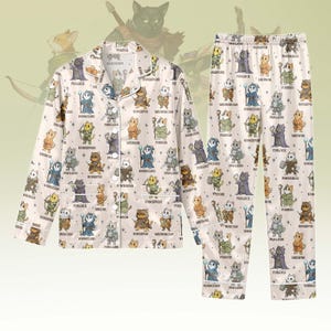 Könnte beinhalten: Ein beiges Pyjama-Set mit einem sich wiederholenden Muster von Cartoon-Katzen in Fantasy-Kleidung. Das langärmlige Hemd und die Hose haben weiße Verzierungen. Die Katzenfiguren sind in verschiedenen Posen dargestellt, mit Etiketten wie "Furlock" und "Meownk".