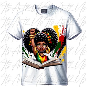 May include: A white t-shirt with a colorful graphic design featuring a young Black girl with an afro, wearing glasses and holding a book. The girl is raising her fist in the air. The background is a colorful splatter of paint.
