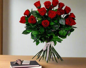 May include: A bouquet of deep red roses with green leaves tied together with a white ribbon.