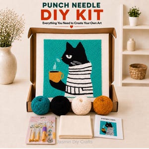 May include: A punch needle DIY kit in a cardboard box containing a square fabric panel with a black cat in a striped sweater holding a yellow mug on a teal background, four yarn balls in teal, black, cream, and mustard, needles, and instructions.