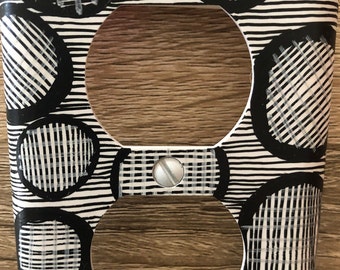 Tapa de enchufe pintada a mano: ilusión de círculos en blanco y negro