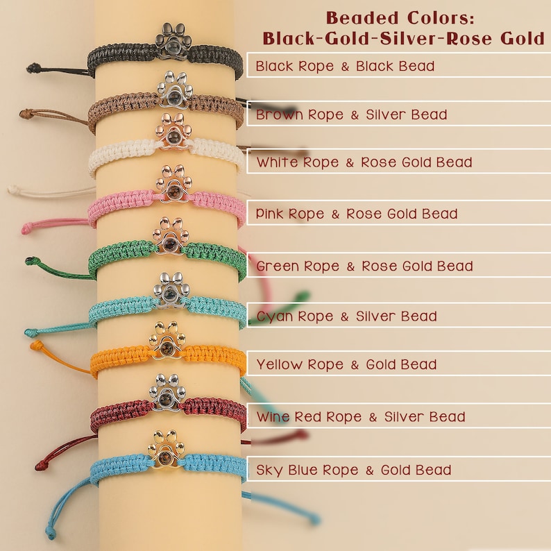 May include: Ten bracelets with different colored ropes and beads. The beads are paw prints with a clear center. The rope colors are black, brown, white, pink, green, cyan, yellow, wine red, and sky blue. The beads are black, silver, rose gold, and gold.