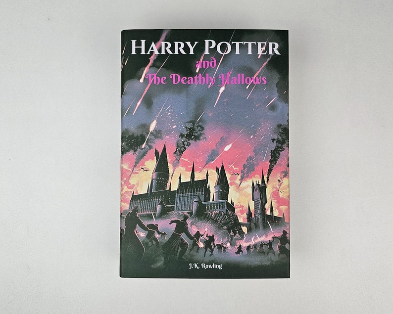 K&ouml;nnte beinhalten: Ein Buchcover f&uuml;r "Harry Potter und die Heiligt&uuml;mer des Todes" von J.K. Rowling. Das Cover zeigt eine dunkle Silhouette von Hogwarts mit einem rosa und violetten Himmel mit fallenden Sternen.