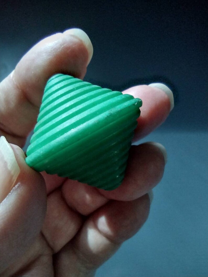 May include: A green, ribbed, cone-shaped toy with a pointed tip.