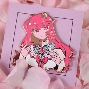 Puede incluir: Un pin de esmalte rosa y blanco con un personaje de dibujos animados con cabello rosa, un vestido blanco y un diseño en forma de corazón en el pecho. El personaje tiene un lazo rosa en la cabeza y sostiene un corazón en sus manos.
