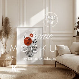 May include: A white frame mockup with a minimalist black and red floral illustration inside. The frame is on a light brown rug in a white room with a white couch and a potted plant.