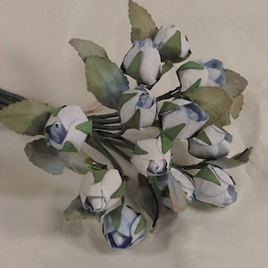 May include: A bouquet of artificial blue and white roses with green stems and leaves.