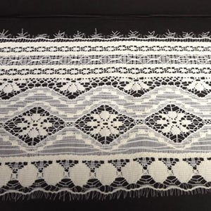 May include: A collection of white lace trims with various patterns, including floral, geometric, and scalloped edges. The trims are displayed against a black background, showcasing the intricate details and textures of the lace.