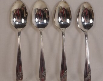 May include: Four silver teaspoons with ornate floral designs on the handles.