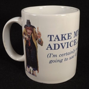 Op de afbeelding: Witte keramische koffiemok met een cartoonillustratie van een man in een lange jas en hoed. De tekst op de mok luidt "Take My Advice... (I'm certainly not going to use it)"