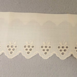 May include: White cotton lace trim with a scalloped edge and a repeating pattern of grapes.