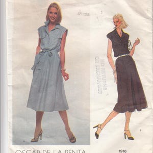 May include: Vogue American Designer sewing pattern 1916 by Oscar de la Renta. The envelope features illustrations of two midi-length shirt dresses with short sleeves, collars, button-front closures, chest pockets, and waist ties in light blue and dark brown.